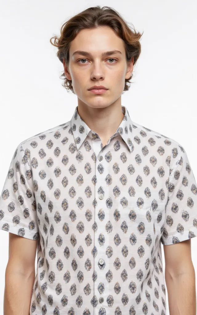 A French model wearing an Oval pattern   printed shirt, against a white background, in a front   facing bust portrait
